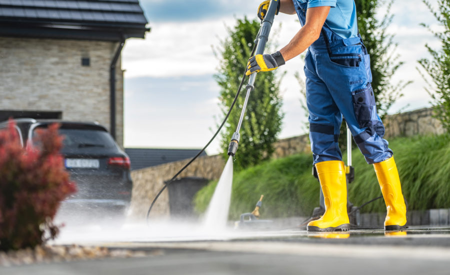 Mitarbeiter Mit Hochdruckreiniger Säubert Gepflasterte Außenfläche – Professionelle Grauflächenreinigung Durch Optima Gebäudeservice Nord Gmbh In Lübeck Und Hamburg