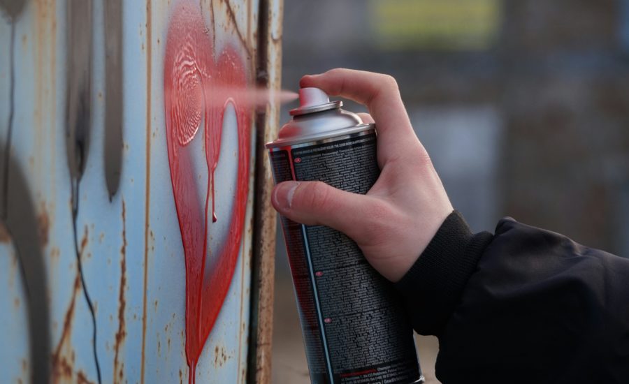 Person Sprüht Rotes Herz Mit Farbdose Auf Metallwand – Symbolbild Für Graffiti Und Vorbeugung Von Vandalismus